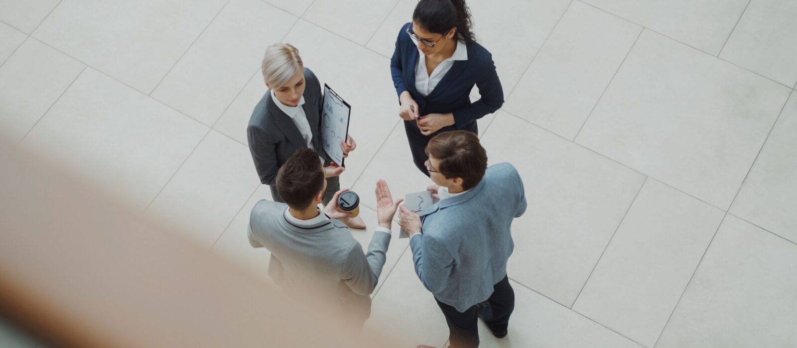 Overhead shot of diverse business team discussing a project indoors.