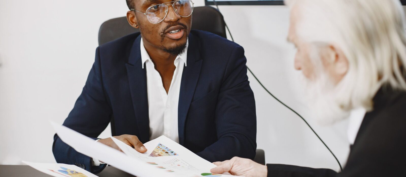 Two businessmen engaged in a meeting discussing charts and documents.