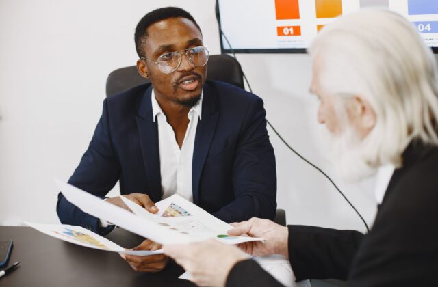 Two businessmen engaged in a meeting discussing charts and documents.